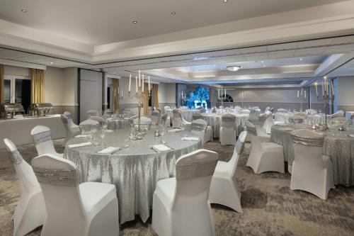 a banquet room with white tables and white chairs at Delta Hotels by Marriott Tudor Park Country Club in Maidstone