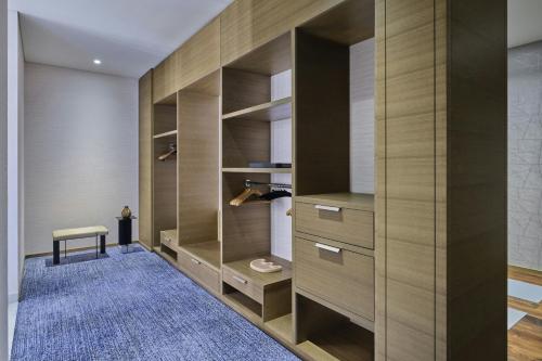 a walk in closet with wooden cabinets and a blue rug at The St. Regis Chicago in Chicago