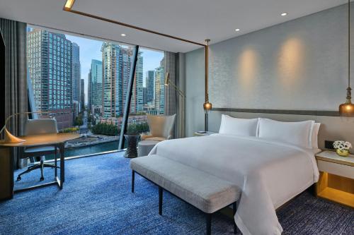 a bedroom with a bed and a desk and a large window at The St. Regis Chicago in Chicago