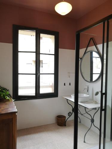 une salle de bain avec un lavabo et un miroir dans l'établissement Maison provençale, piscine, calme et Lubéron, au Thor