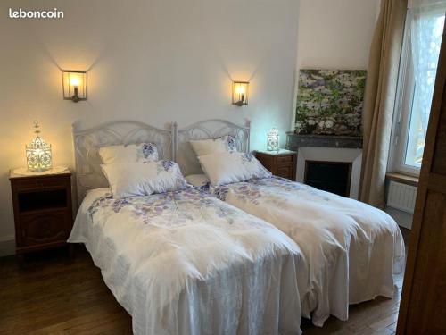 - une chambre avec 2 lits avec des draps blancs et une cheminée dans l'établissement Gîtes à la ferme de la Seille Lorraine, à Létricourt