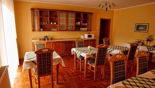 uma sala de jantar com mesas e cadeiras e uma cozinha em Euro Panzio em Debrecen