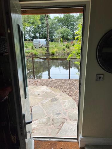 an open door with a view of a pond at The Old Chicken Shed in Stafford