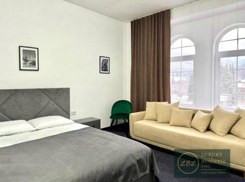 a hotel room with a bed and a couch at Villa Sicilia in Yaremche