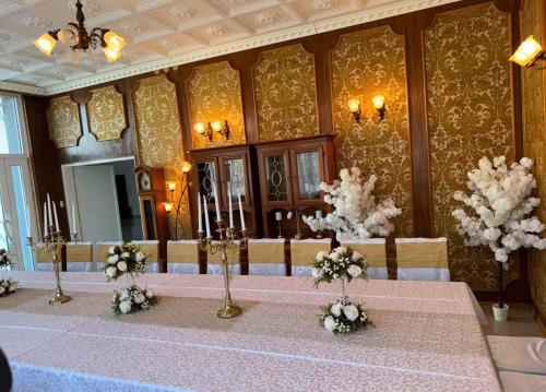 a room with a table with flowers on it at Hotel Oaza in Kikinda