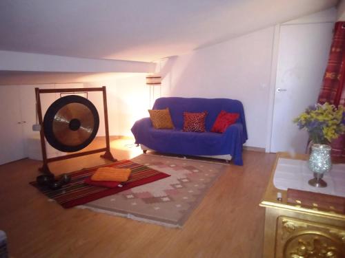 a living room with a blue couch and a fan at Next stop room in Azurara