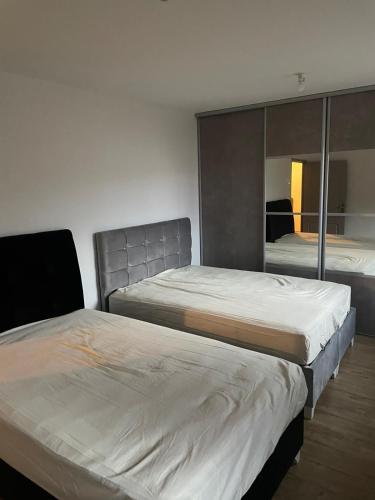 une chambre avec deux lits et un miroir dans l'établissement Recent home, à Aubière