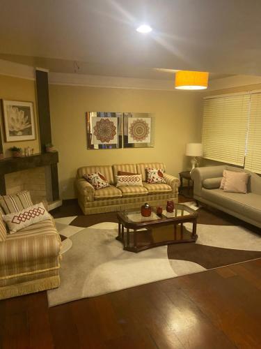 a living room with couches and a coffee table at Apto Familiar 4 QUARTOS E 2 BANHEIRO in Uruguaiana