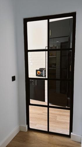 a room with a glass door to a kitchen at La Casa del Escudo in Trujillo
