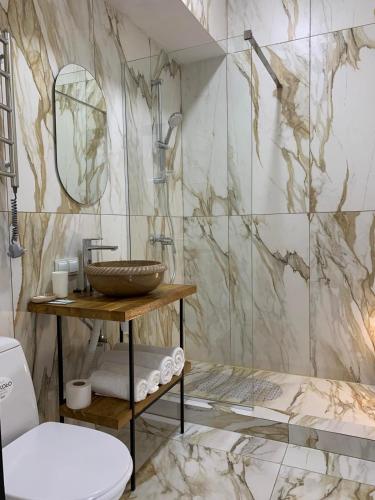 a bathroom with a sink and a marble wall at Villa Sicilia in Yaremche