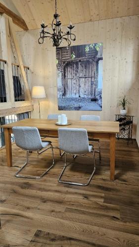 a dining room with a wooden table and chairs at Salzhaus in Amsoldingen