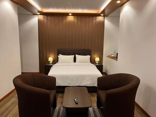 a bedroom with a bed and two chairs at Blooming Rose Ella in Ella