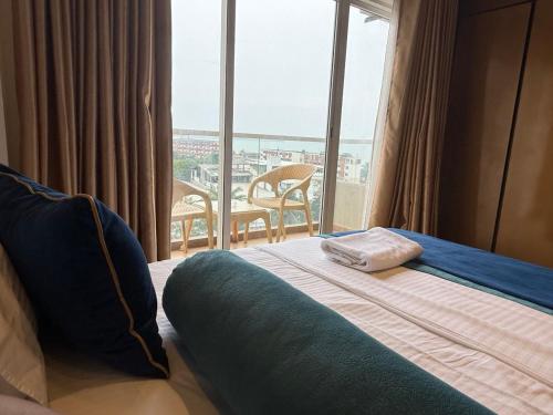 a hotel room with a bed and a large window at Negombo Ocean Breeze - ShoresEdge Luxury Apartments in Negombo