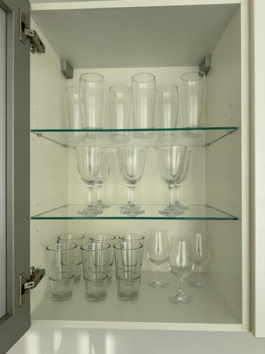 a bunch of wine glasses sitting on glass shelves at "Cooles Ferienhaus!" - im Coburger Wonderland - Ihr Zuhause auf Zeit! in Coburg