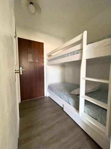 - une chambre avec 2 lits superposés et une porte dans l'établissement Cigales de la Mer - climatisé, vue mer et parking, au Grau-du-Roi