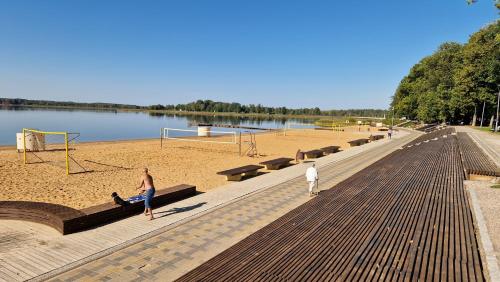 two men standing on a boardwalk next to a lake at Apartment vanalinnas in Võru