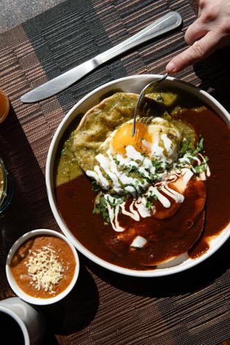 a bowl of food with an egg on a table at Best Western Plus San Jorge in Ciudad Obregón