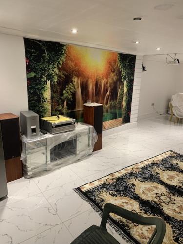 a living room with a painting on the wall at Air B and P in Seven Kings