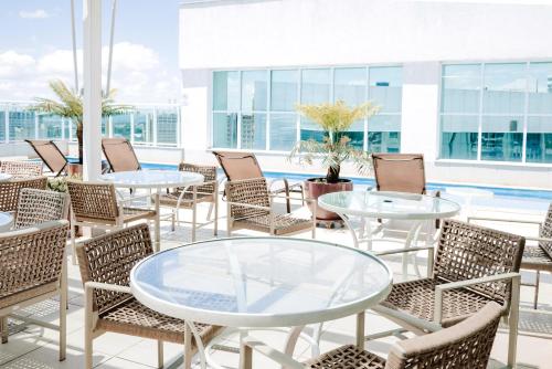 a patio with tables and chairs and a pool at Flat II em Saint Morizt Brasília Hotel in Brasilia