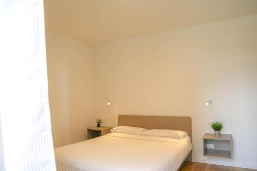 a bedroom with a white bed with two plants on it at Barchessa Cappelletto in Torre di Mosto