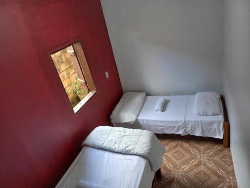 ein kleines Zimmer mit zwei Betten und einem Fenster in der Unterkunft Casa guarirobas in Alto Paraíso de Goiás