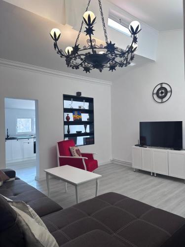 a living room with a couch and a chandelier at Central Park Bragadiru Loft in Bragadiru