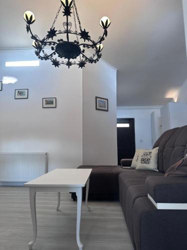 a living room with a couch and a chandelier at Central Park Bragadiru Loft in Bragadiru