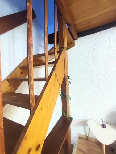 un escalier en colimaçon en bois dans une pièce avec une table dans l'établissement Maison typique de village Corse , 10 min aéroport et de la mer, à Prunelli-di-Casacconi