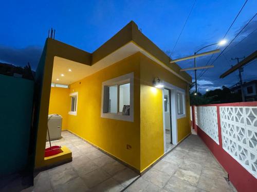 a house with a yellow wall and a white fence at Finca El Fraile in Monterrey