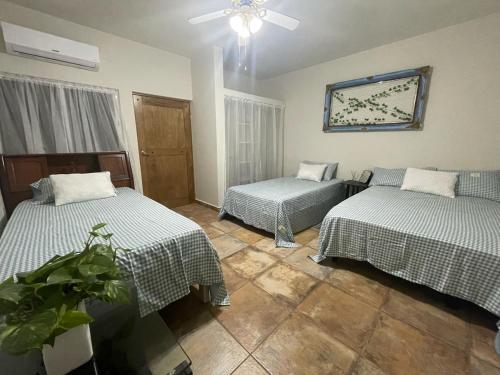 een kamer met twee bedden en een plafondventilator bij Finca El Fraile in Monterrey