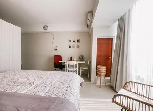 Studio Almahyra Alana Jogja في Kejayan: غرفة نوم بها سرير وطاولة وكراسي