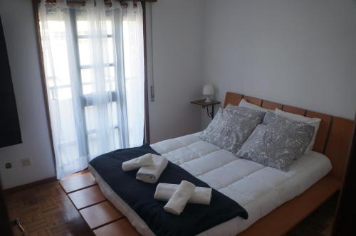 a bedroom with a bed with two towels on it at Casa no centro histórico in Vila Nova de Gaia