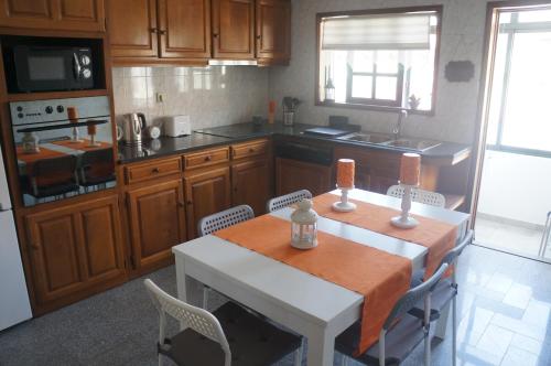 a kitchen with a table and chairs and a kitchen with wooden cabinets at Casa no centro histórico in Vila Nova de Gaia