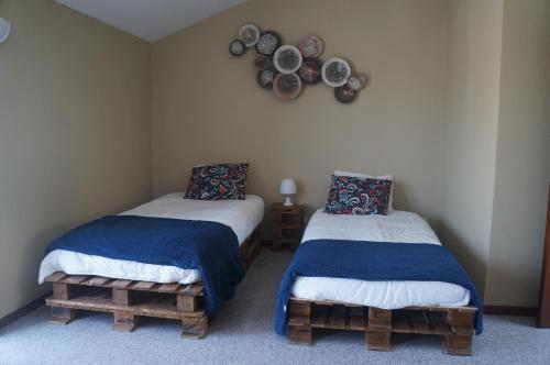 two beds in a room with plates on the wall at Casa no centro histórico in Vila Nova de Gaia