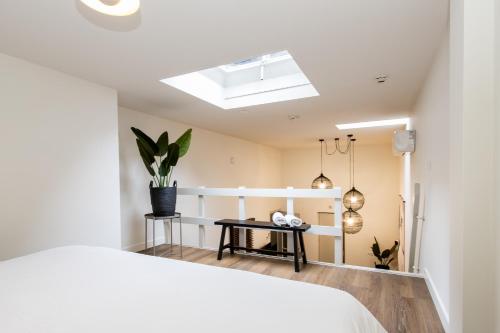 a bedroom with a white bed and a skylight at HOLT Hotel in Nijmegen