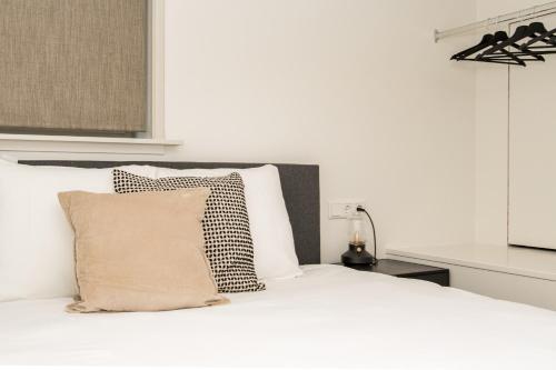 a white bed with a black and white pillow at HOLT Hotel in Nijmegen