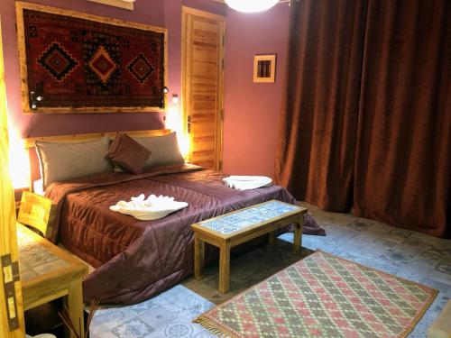 a bedroom with a bed with a table on it at Villa A'Kabar Guest House in Tamdakht