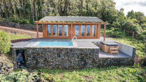 a house with a pool and a gazebo at Adega da Quinta - Casa da Ioio in Madalena