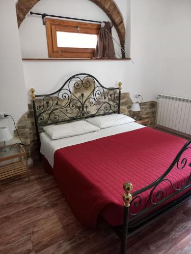 a bedroom with a bed with a red blanket at B&B Il Pittore in Borgo San Lorenzo