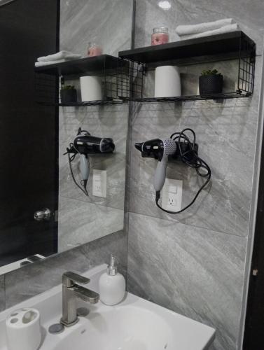 a bathroom sink with a blow dryer on a wall at Cozy apartment & pool in Villa de Alvarez
