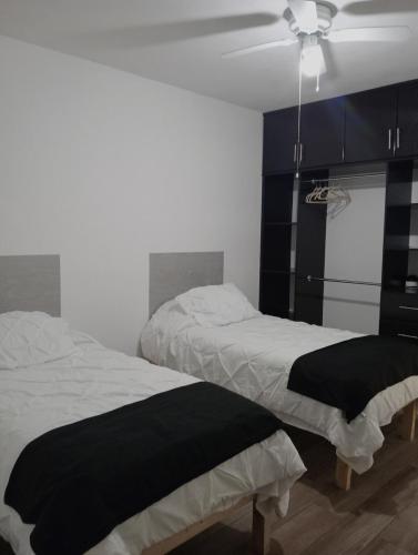 a bedroom with two beds and a ceiling fan at Cozy apartment & pool in Villa de Alvarez