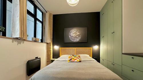 une chambre avec un lit avec un oreiller dessus dans l'établissement Loft moderne Saint-Ambroise, à Paris