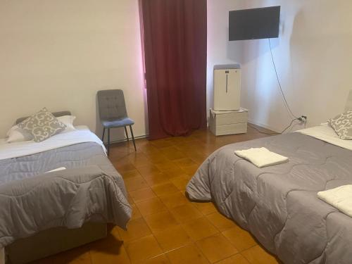 a room with two beds and a chair and a television at Good Morning Venice in Venice