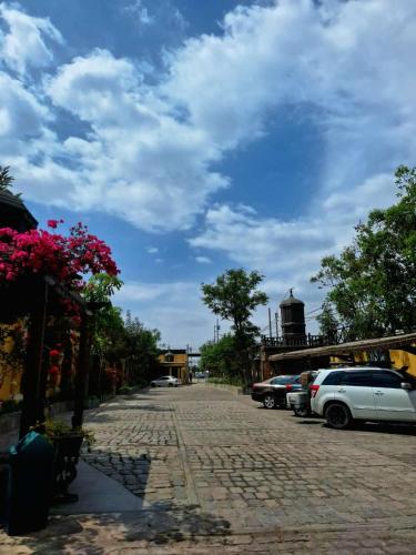 a cobblestone street with cars parked on the side at Hotel & Hacienda El Carmelo in Ica