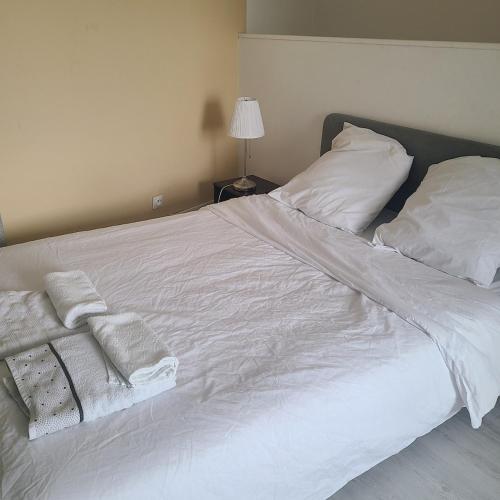 un lit blanc avec des draps et des oreillers blancs dans l'établissement Duplex Brest Pilier Rouge, à Brest