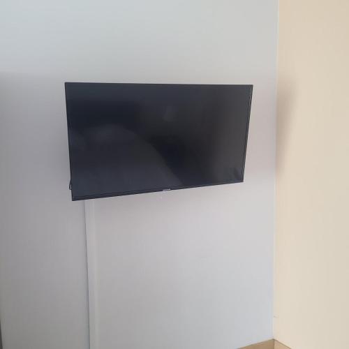 Elle comprend une télévision à écran plat suspendue sur un mur blanc. dans l'établissement Duplex Brest Pilier Rouge, à Brest