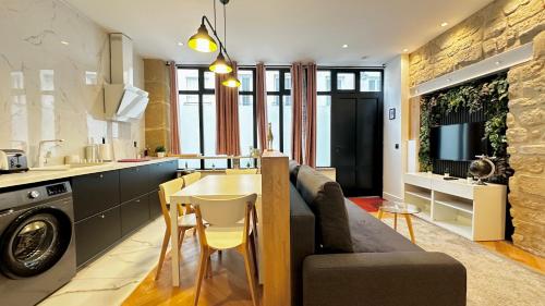 une cuisine et un salon avec un canapé et une table dans l'établissement Loft moderne Saint-Ambroise, à Paris