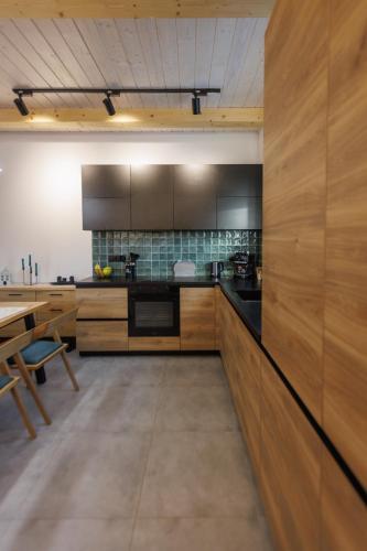 a large kitchen with wooden cabinets and a table at Carpathians View in Krivopolʼye