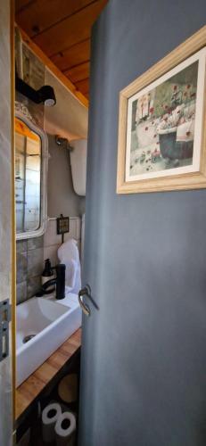 a bathroom with a sink and a door with a picture at El viejo garage in Mar de Ajó