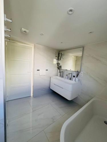 a bathroom with a sink and a tub and a mirror at Maison - St Jean de Luz - Proche de la plage in Saint-Jean-de-Luz